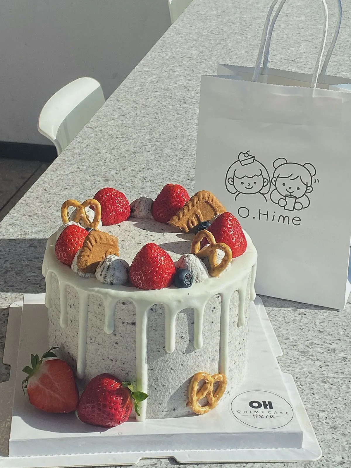 Oreo cream drip cake with fresh strawberries and pretzel decor at O.Hime Cake, a Bakery in Waterloo