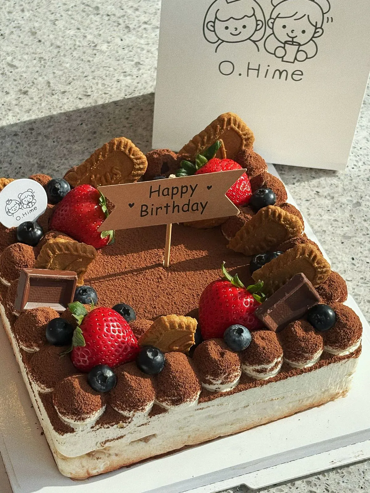 Square tiramisu cake with cocoa powder, strawberries and cookie toppings at O.Hime Cake, a Bakery in Waterloo