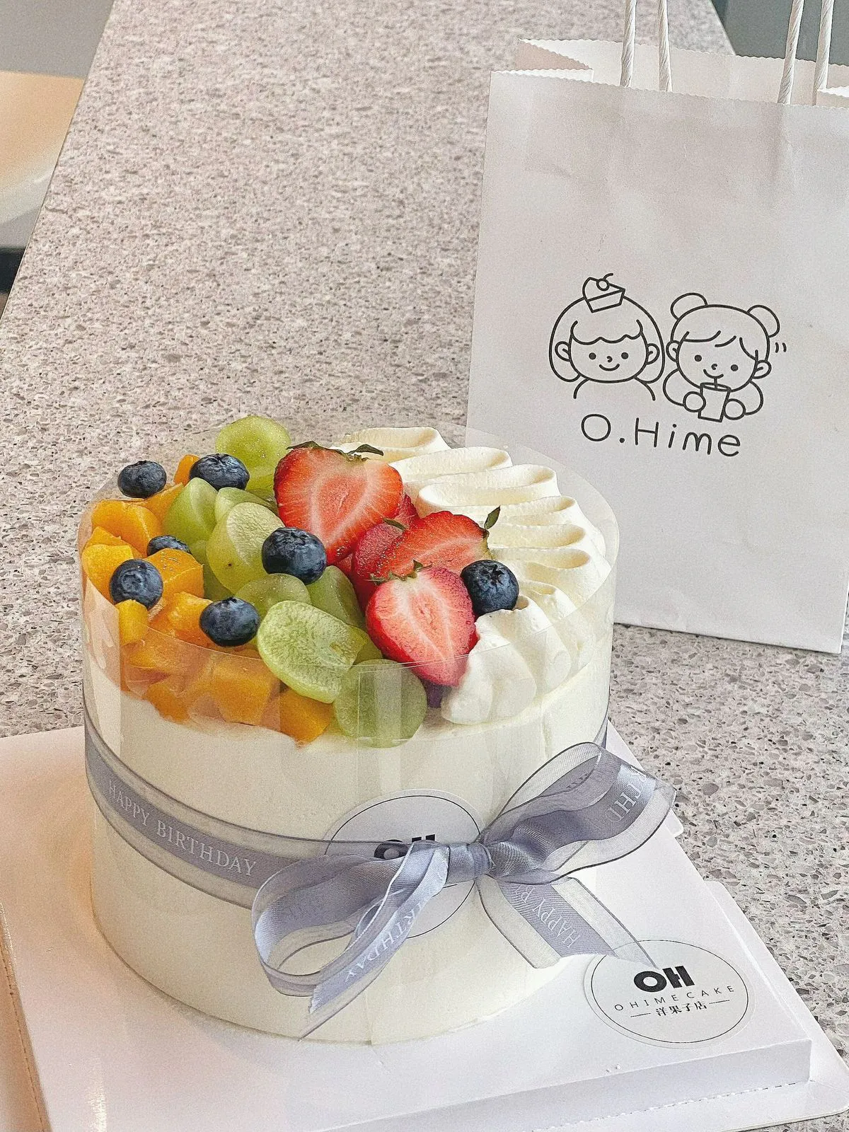 Round fruit cream cake wrapped with gray ribbon and mixed fresh fruits at O.Hime Cake, a Bakery in Waterloo
